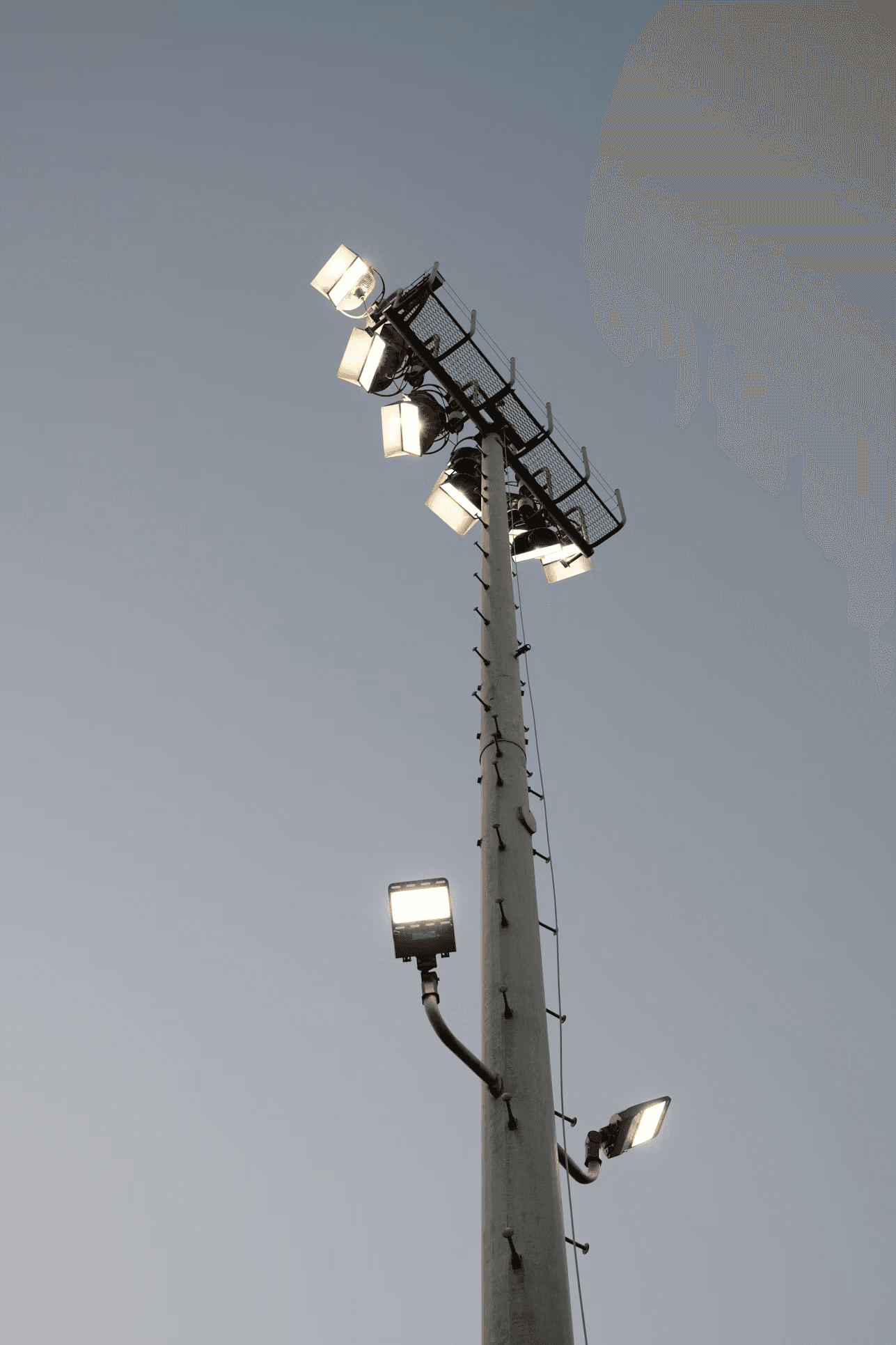 High mast lighting installation against an evening sky