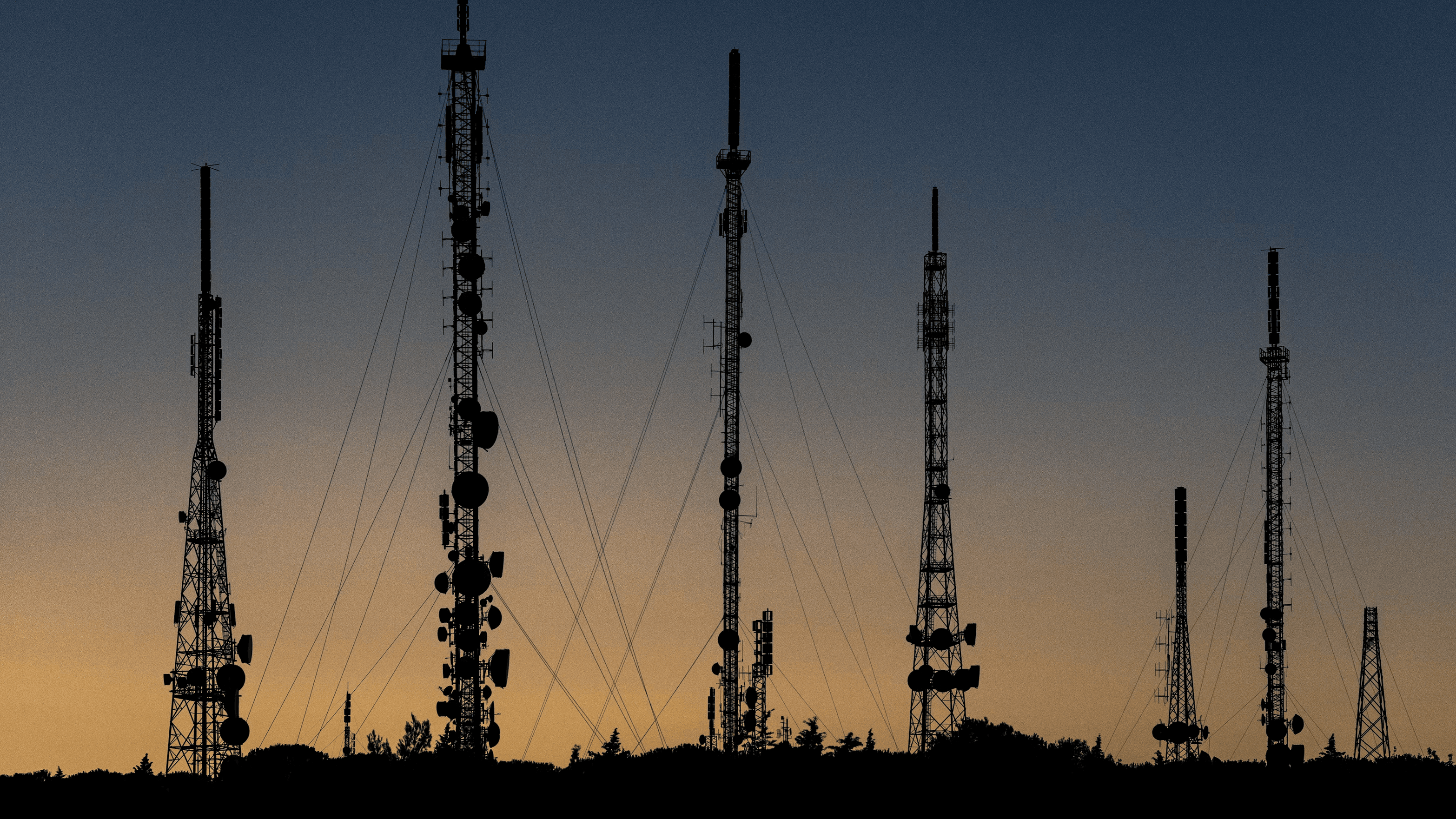 Telecom tower silhouettes at dusk